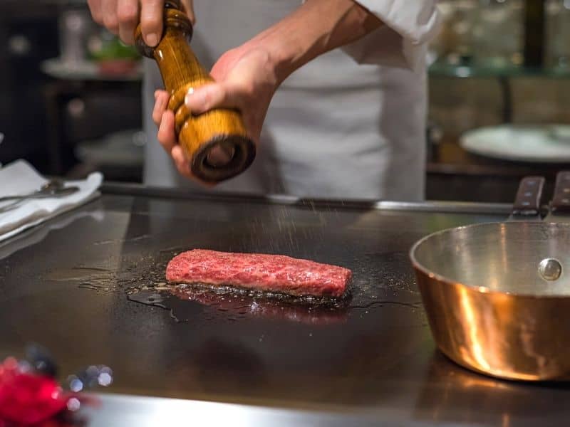 cooking a steak on a teppanyaki grill