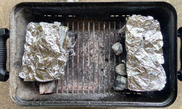 adding wood chips on a charcoal grill