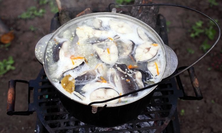 boiling fish soup on a charcoal grill